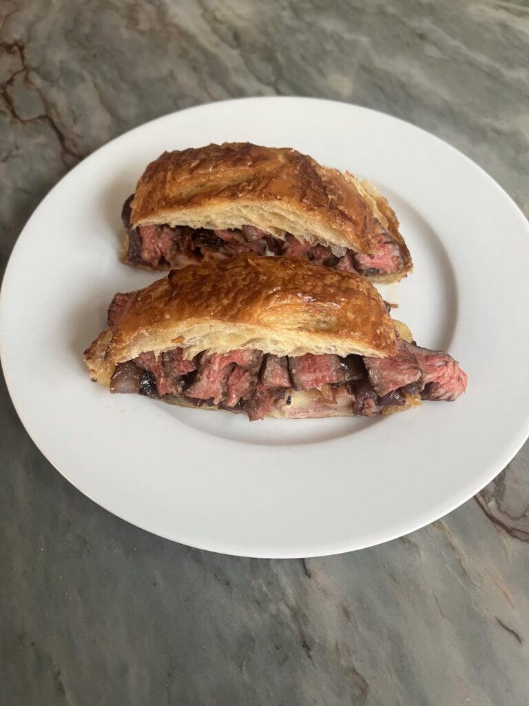 Grilled Delmonico ribeye ham and Gruyère croissant sandwich with sir Kensington mayo and caramelized balsamic onions