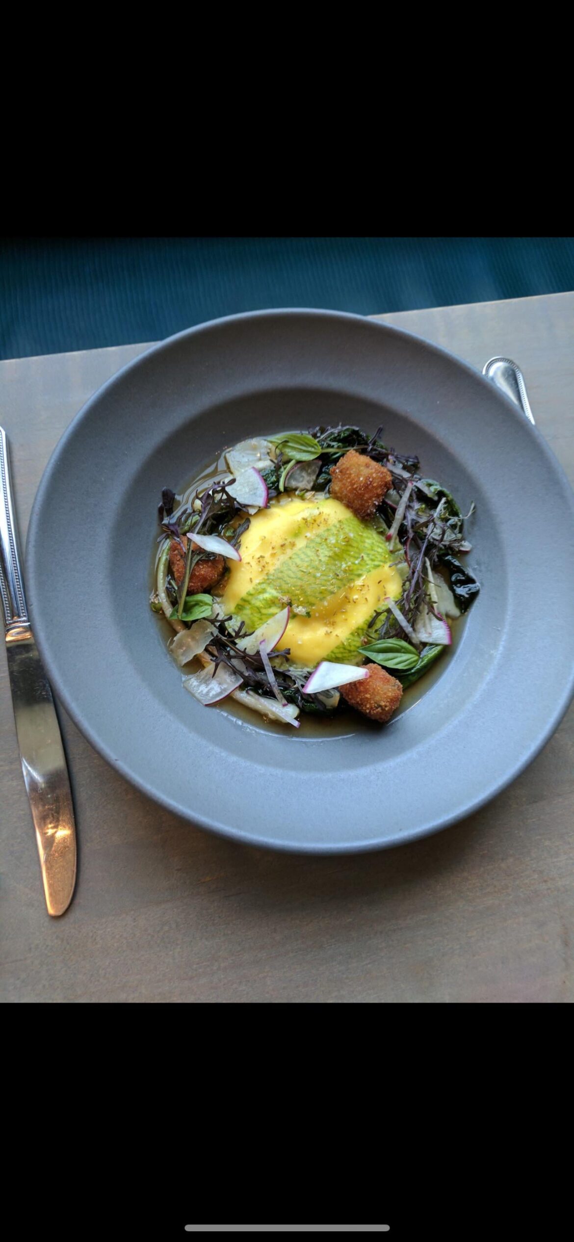 Whole egg ravioli, pork brodo, fried ciccioli, mustard greens, radish.