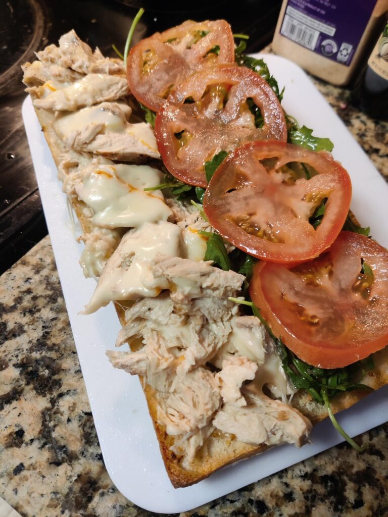 Grilled lemon pepper chicken with melted münster, dressed arugula, tomato on a toasted long ciabatta spread with garlic sauce.