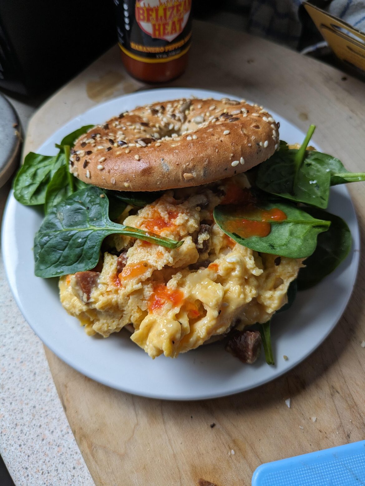 Scrambled eggs with Spanish chorizo and Scottish vintage cheddar on babyleaf spinach in a toasted high-protein bagel