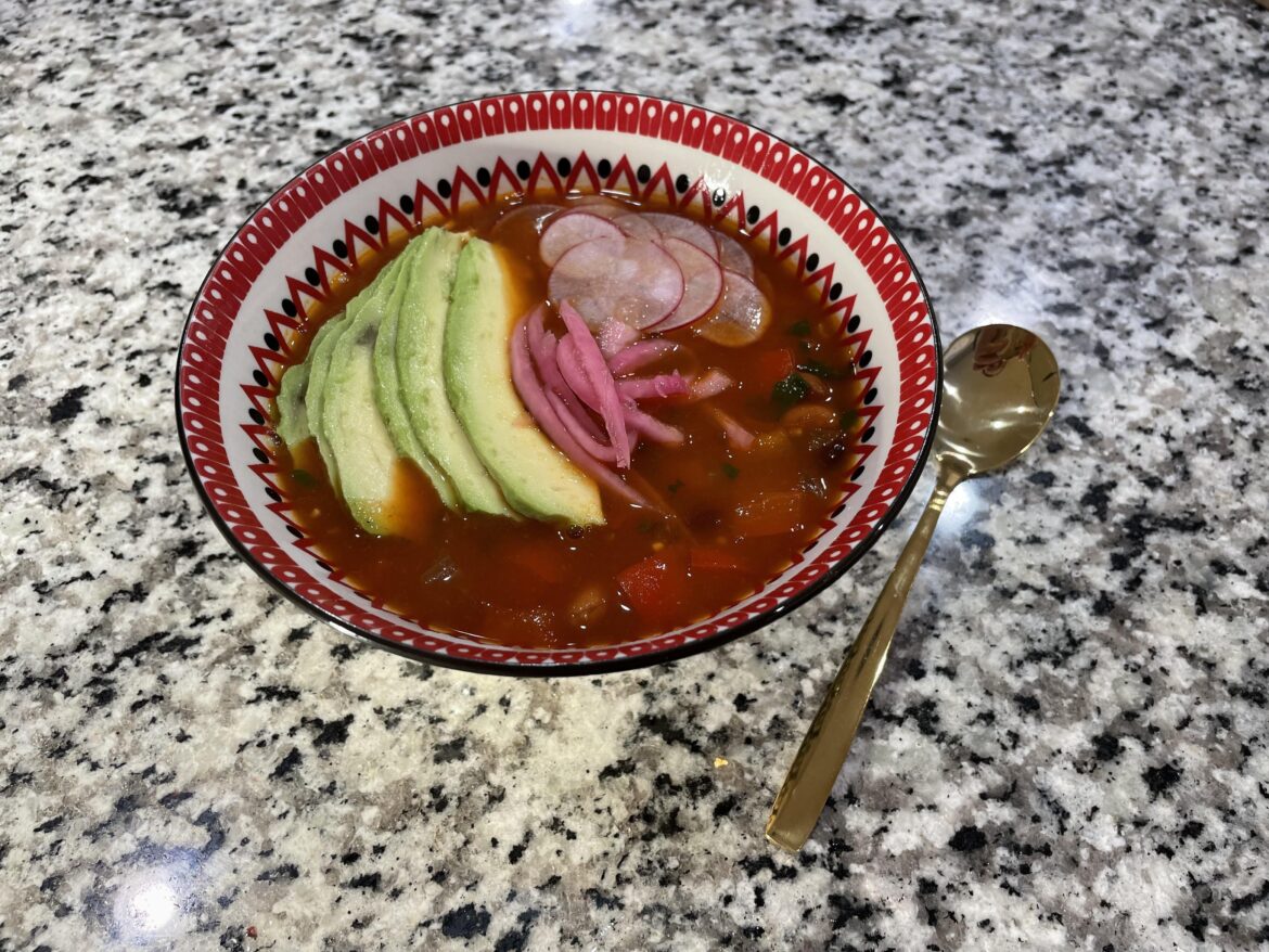 Pinto posole garnished with avocado, radish, & pickled red onion