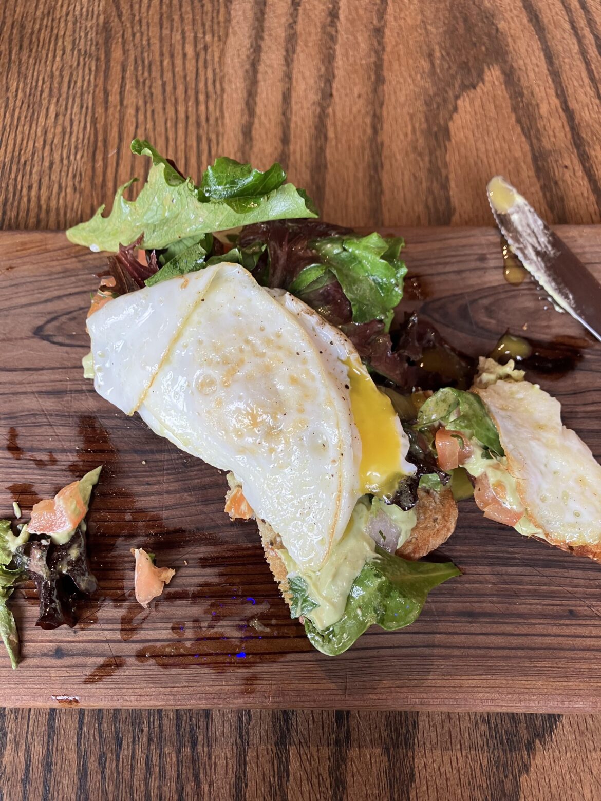 Goddamn runny egg on a plank of wood.