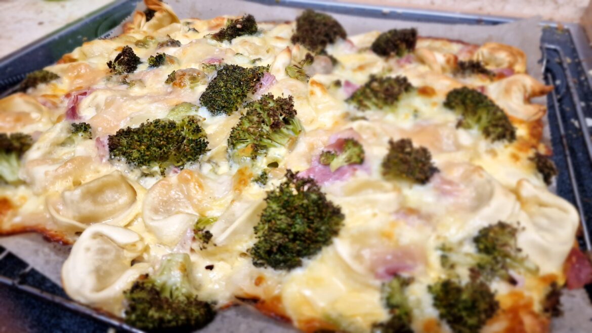 Pizza with Sauce Hollandaise, tortellini, ham, broccoli and a lot of cheese (grated cheese, mozzarella and oarmesan)