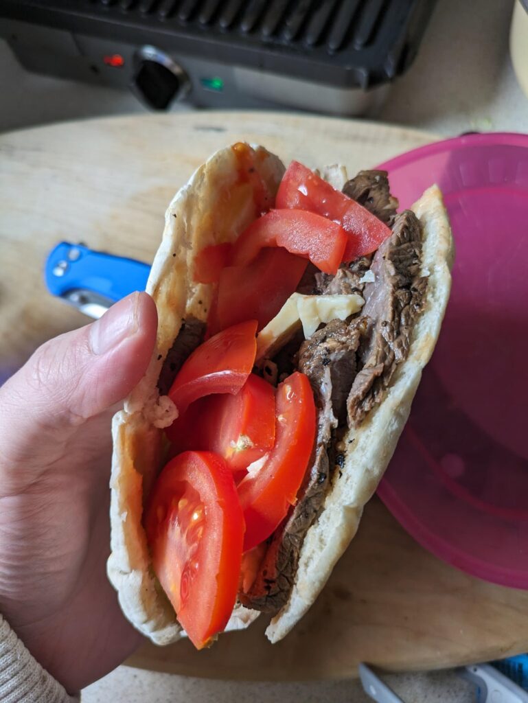 Venison steak, tomato, Scottish vintage cheddar in a pita bread with Marie Sharp's hot sauce.
