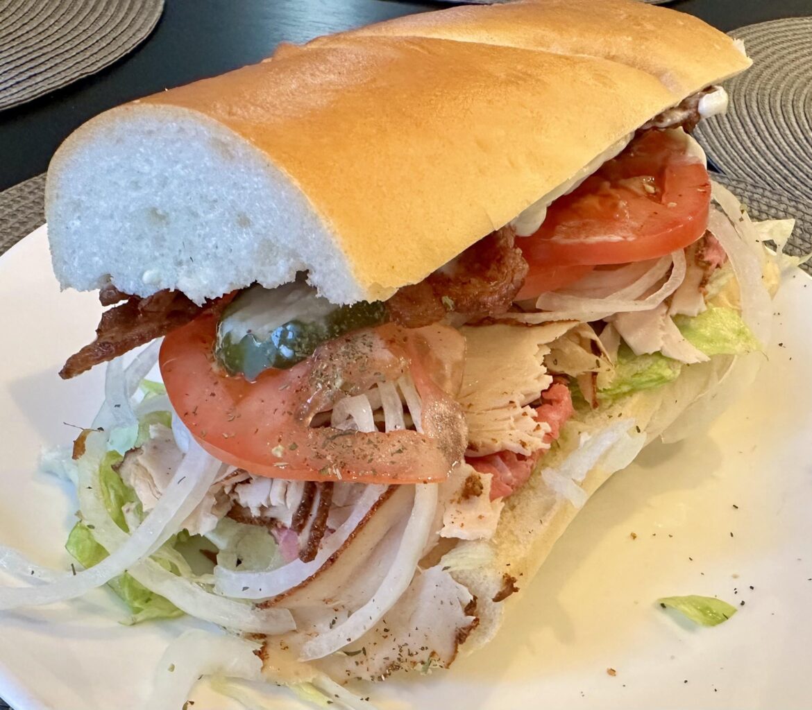 Rare Roast Beef and Smoked Turkey with shredded lettuce, tomatoes, bacon, olive oil/red vinegar/dry spices, thinly sliced onion, mayo on soft roll