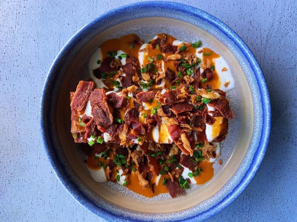 boulangere potato, blue cheese dressing, Louisiana sauce, smoked bacon crumb, crispy shallot, chives