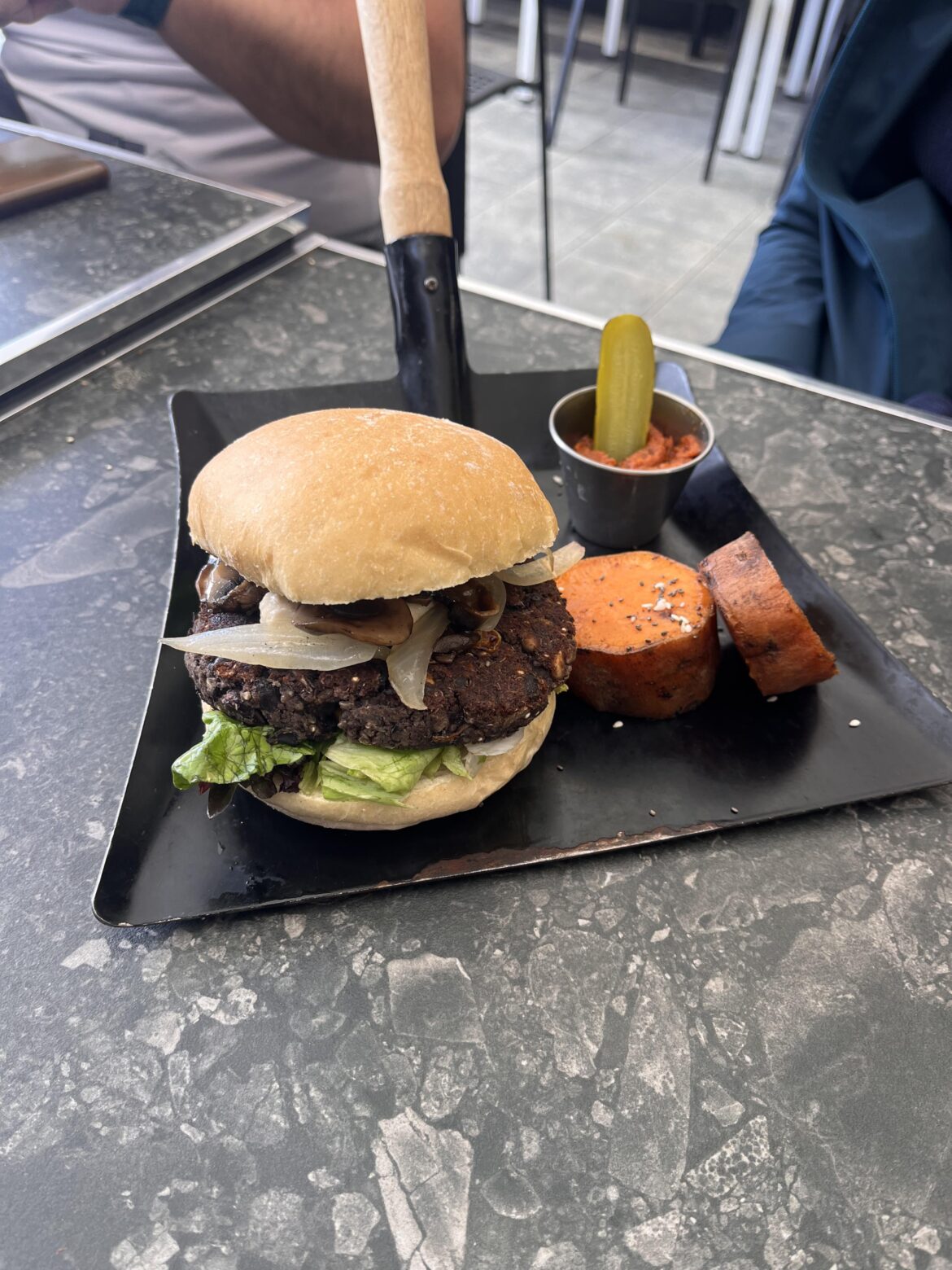 Burger served on a shovel….why? ( all other dishes were served on plates)