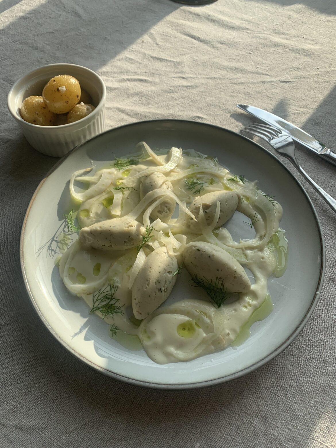 Bass quenelles, fennel and cream sauce, pickled fennel, potatoes.