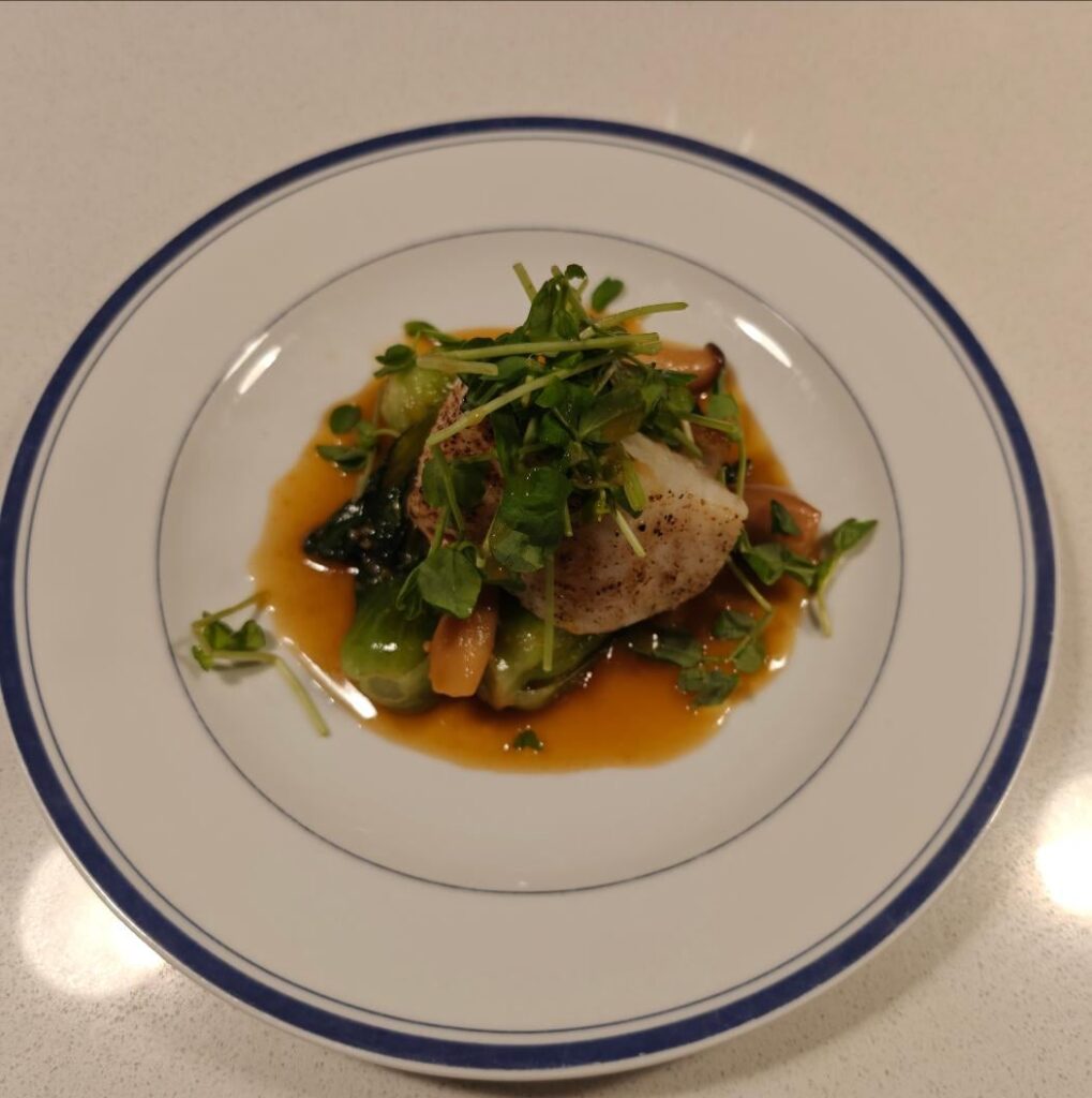 Roasted Sea Bass over Bok Choy with Mini King Oyster Mushroom Miso Sauce and Topped with Pea Sprouts