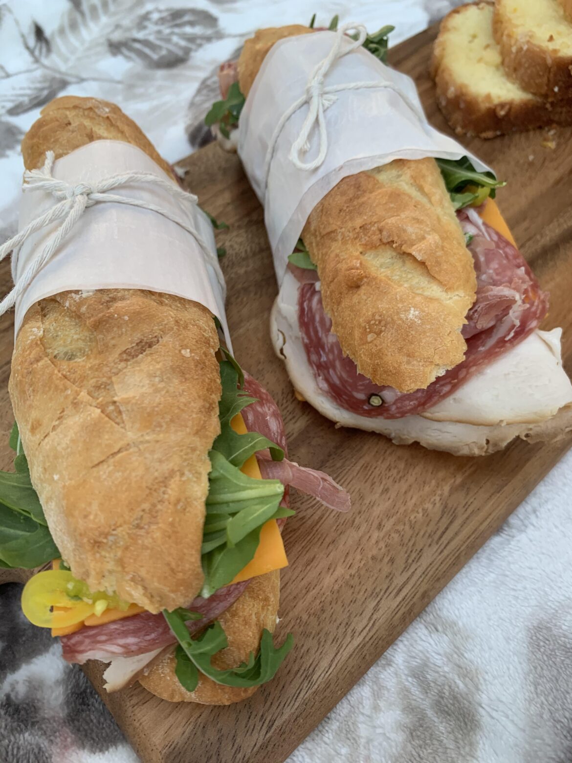 Turkey and salami subs with cheddar cheese, arugula, and hot peppers on baguette