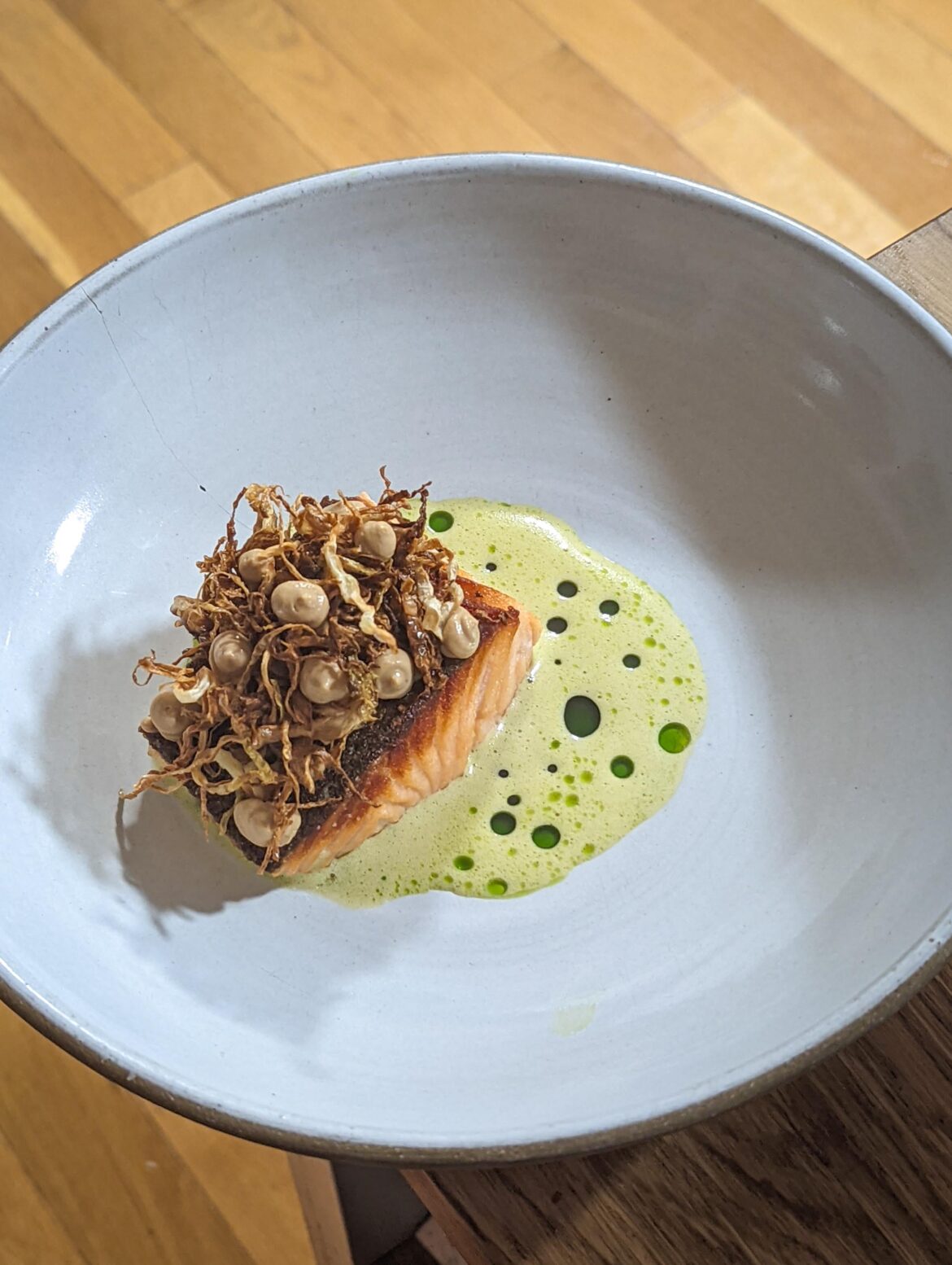 Salmon with crispy cabbage nest, smoked tofu puree, and green tea sabayon broken with cilantro oil