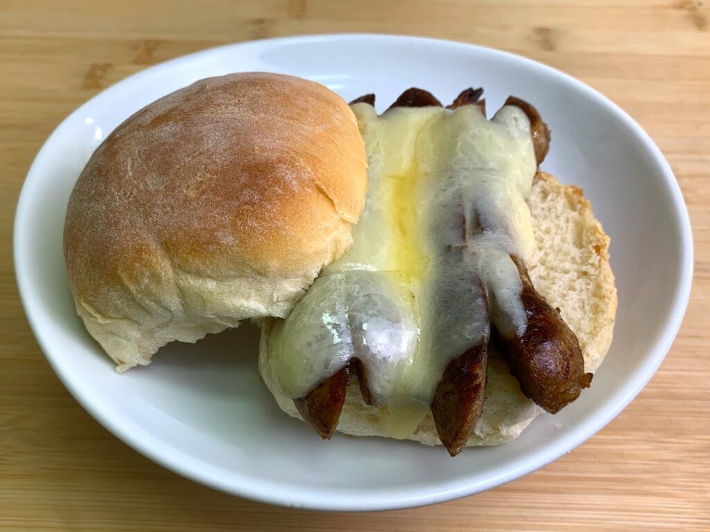 Homemade sage and leek sausages with extra sharp cheddar on a fresh yeast roll