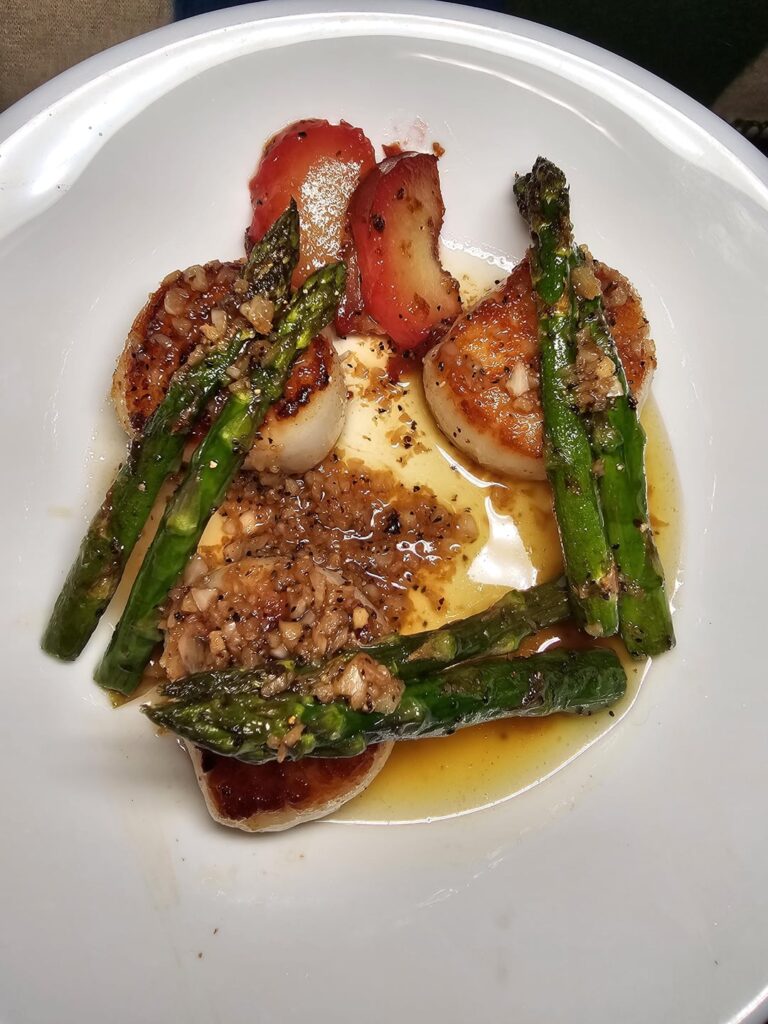 Seared scallops in a wine butter sauce, asparagus.