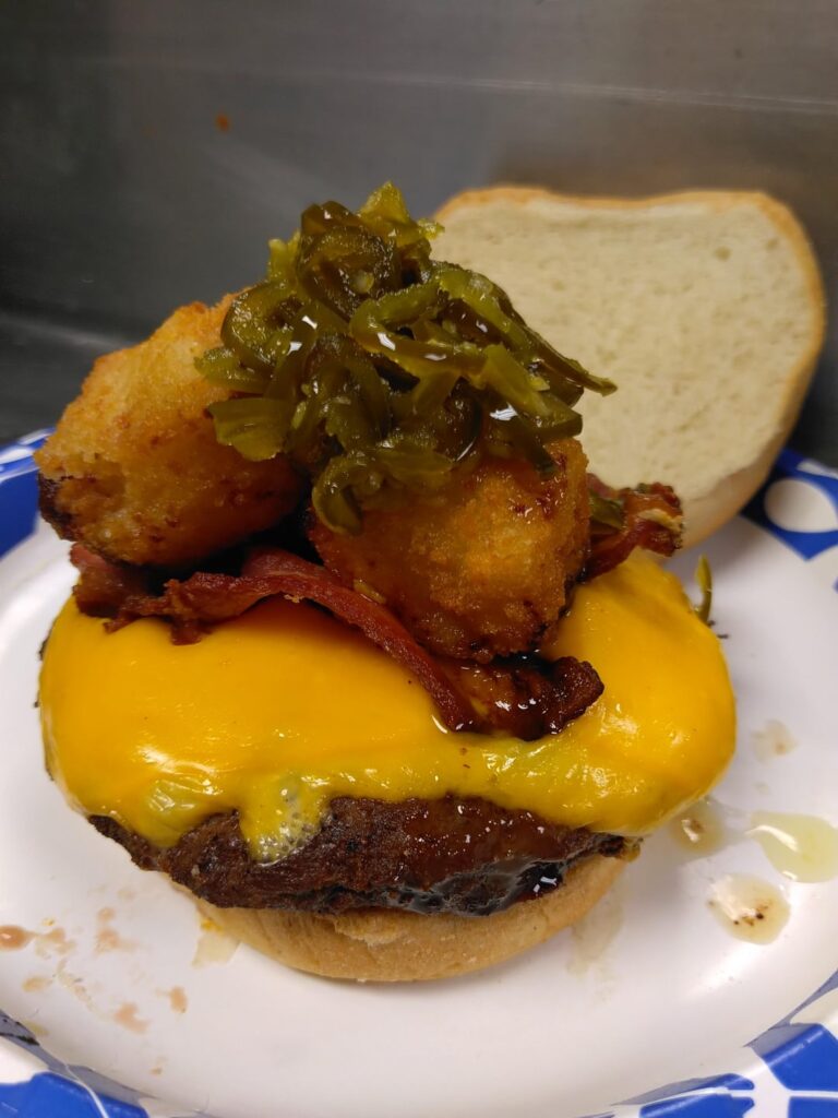 Bacon cheeseburger topped with fried Mac n cheese bites and pickled jalapeno relish