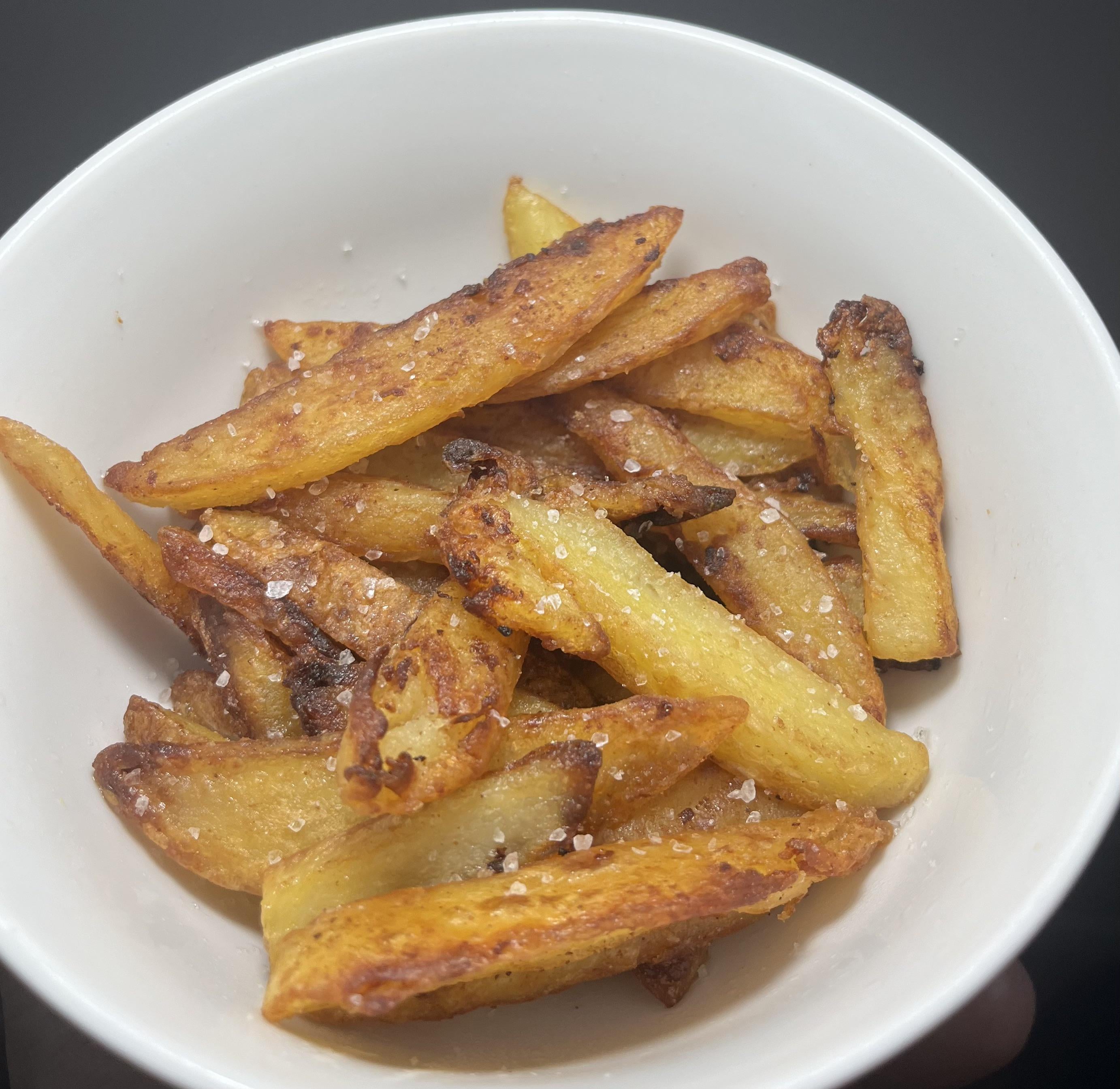 A simple bowl of homemade pan fried chips with sea salt and vinegar