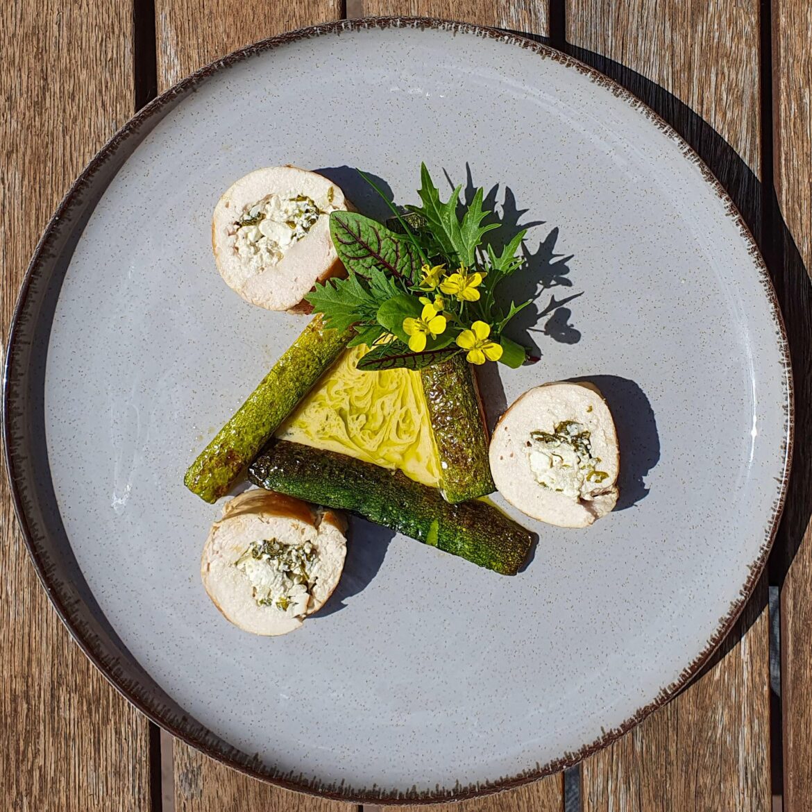 Chicken roulade filled with spinach-garlic feta, pan fried zucchini, beurre blanc, green mint oil and an herb bouquet