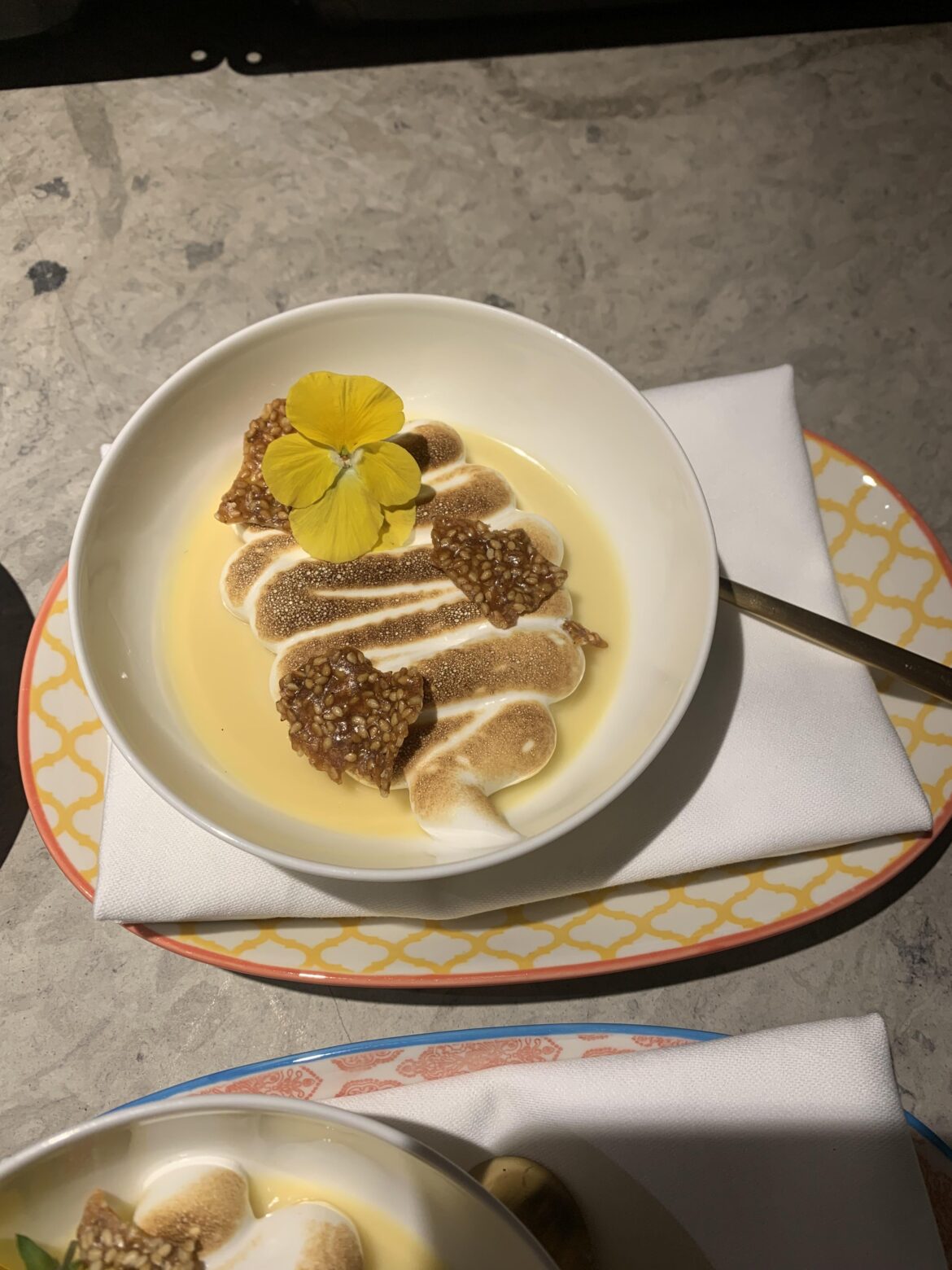 Yuzu posset, torched italian meringue, sesame seed tuile, viola