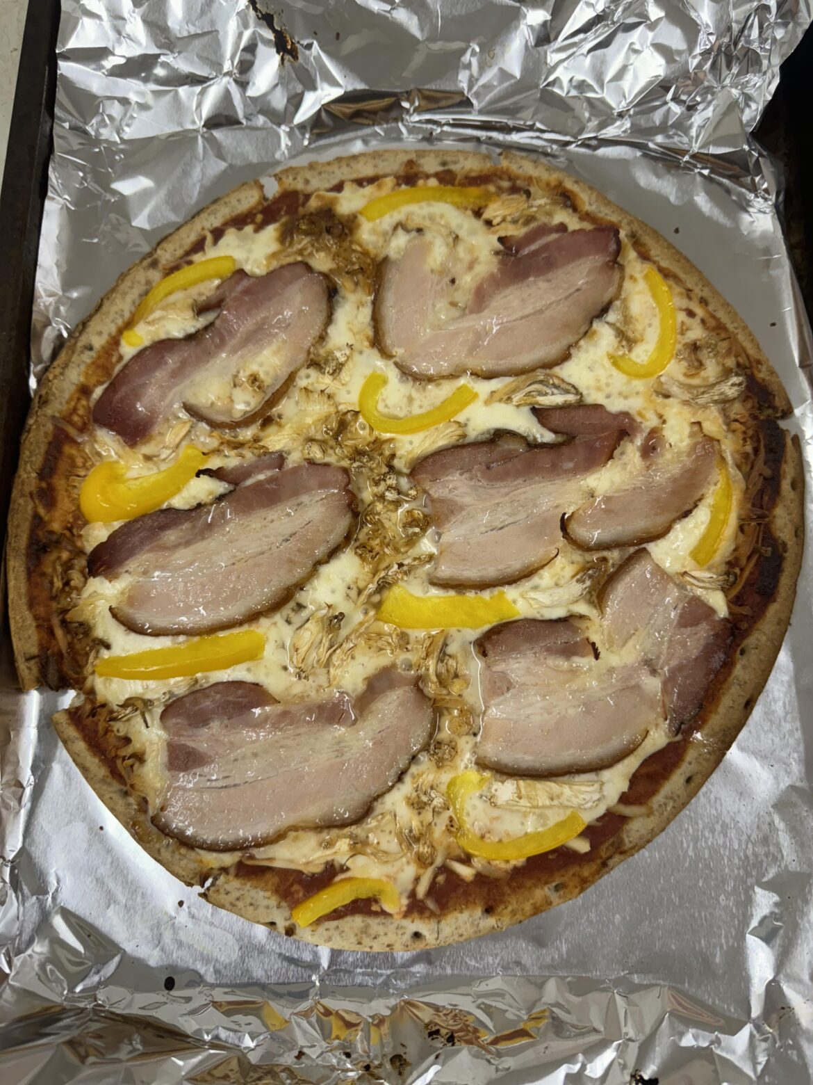 Pizza with tomato base, moz cheese,side bacon, yellow bell pepper & oyster mushrooms