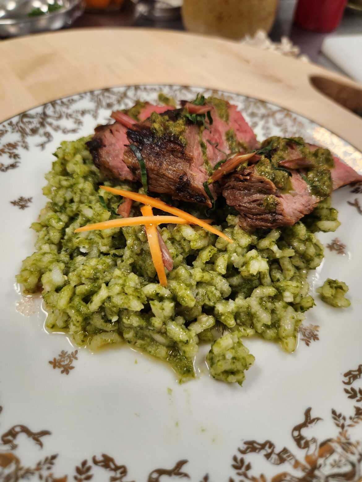 Ramps Risotto Verde with flank steak and ramps chimichurri garnished with pickled carrots and ramp stems