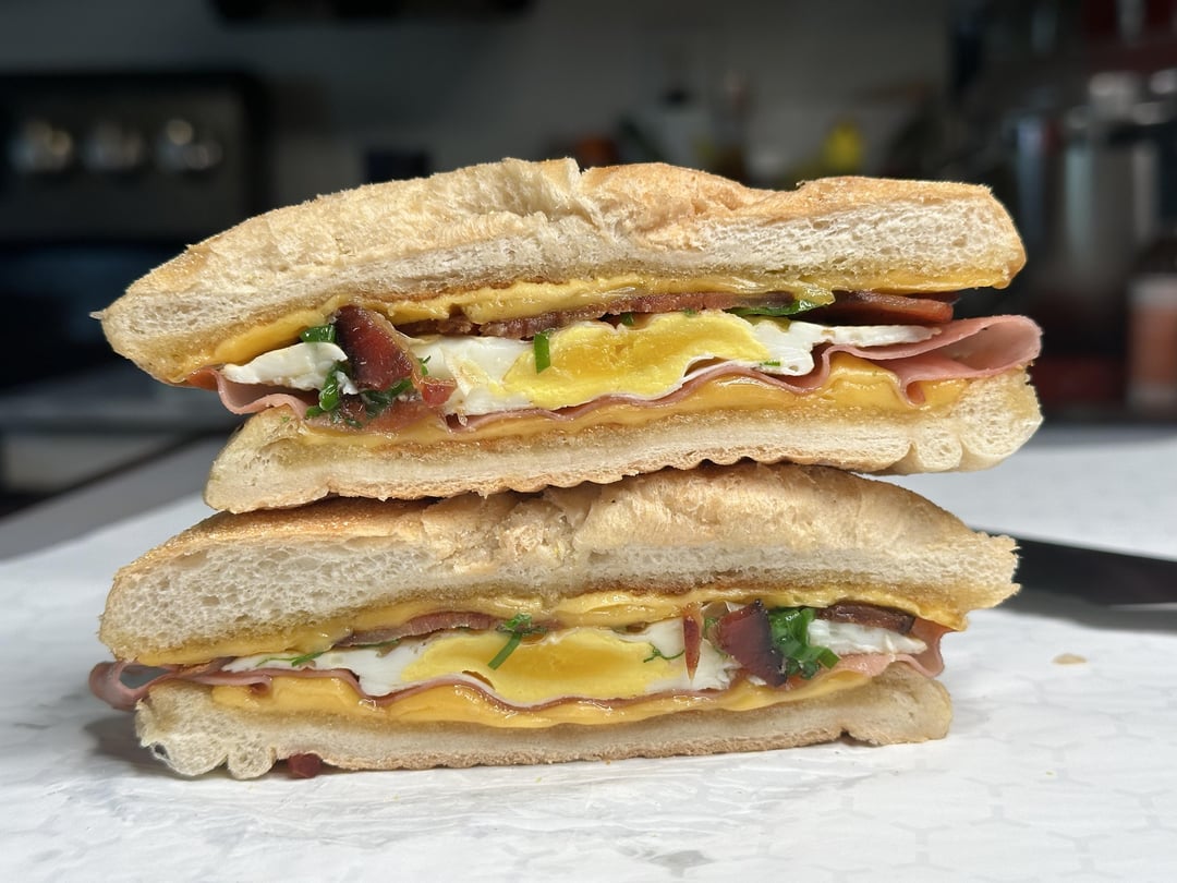 Mortadella, bacon, egg, and cheese breakfast sandwich to go. Dining