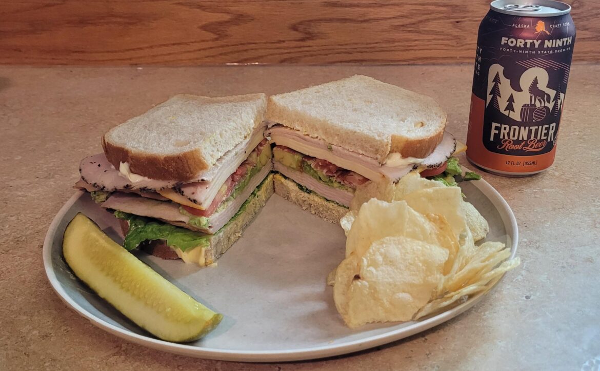 I made a turkey, bacon, tomato, avocado, Munster, lettuce, tomatoe on sourdough. Serves with a dill spear, regular potatoes chips and a Root Beer.