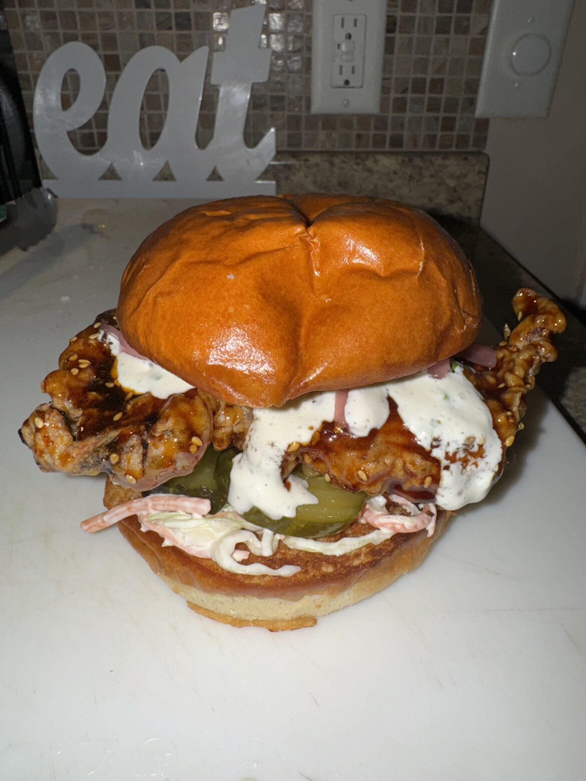 Korean fried chicken sandwich - Korean style fried chicken with a garlic soy glaze, buttermilk chive ranch, hot and sweet pickles, pickled onions, and asian slaw