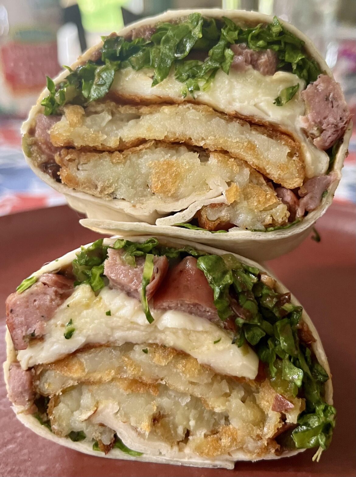 Grilled halloumi, pomegranate syrup, shredduce, pepper relish, chicken sausage, grilled jalapeño, dal spread, and hash browns in a wrap. 😤