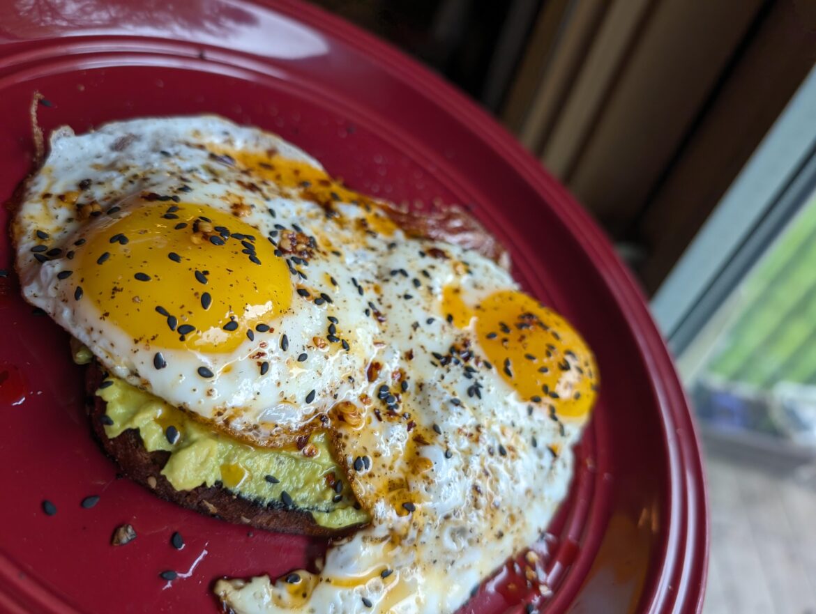 Avocado toast with egg, chili oil, and sesame seeds
