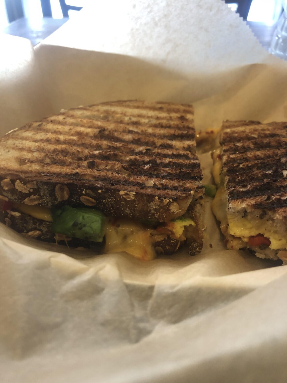 Egg, pepper jack cheese, sriracha, avocado, and roasted red peppers on multigrain bread