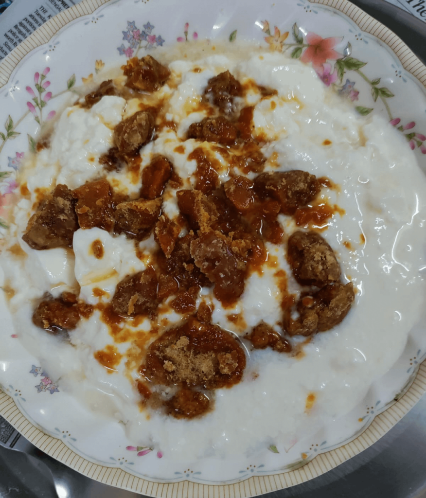 Curd with Flattened rice and some chunks of jaggery.