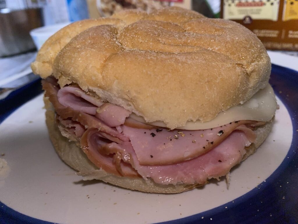 A sandwich: Honey Ham, Last of the Provologne, Dijon Mustard, Black pepper, on a Soft Kaiser Roll