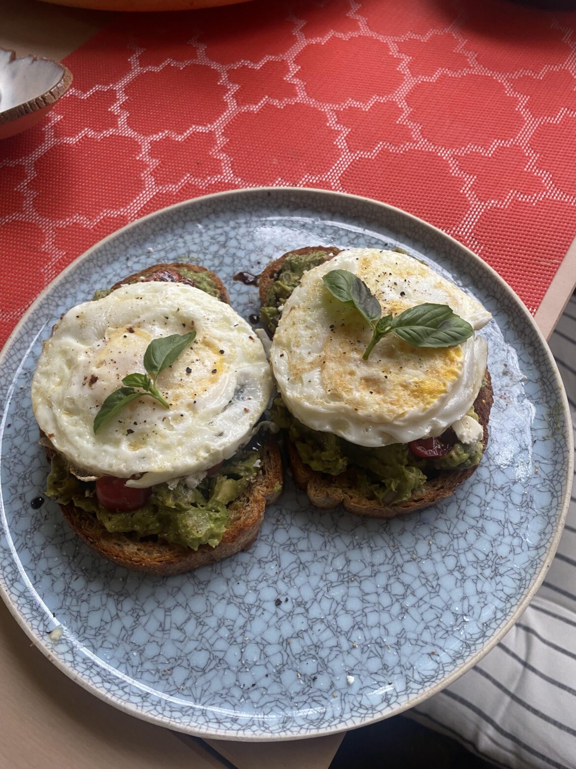 Smashed avocado with feta, tomato, and balsamic glaze. Topped with a fried egg.