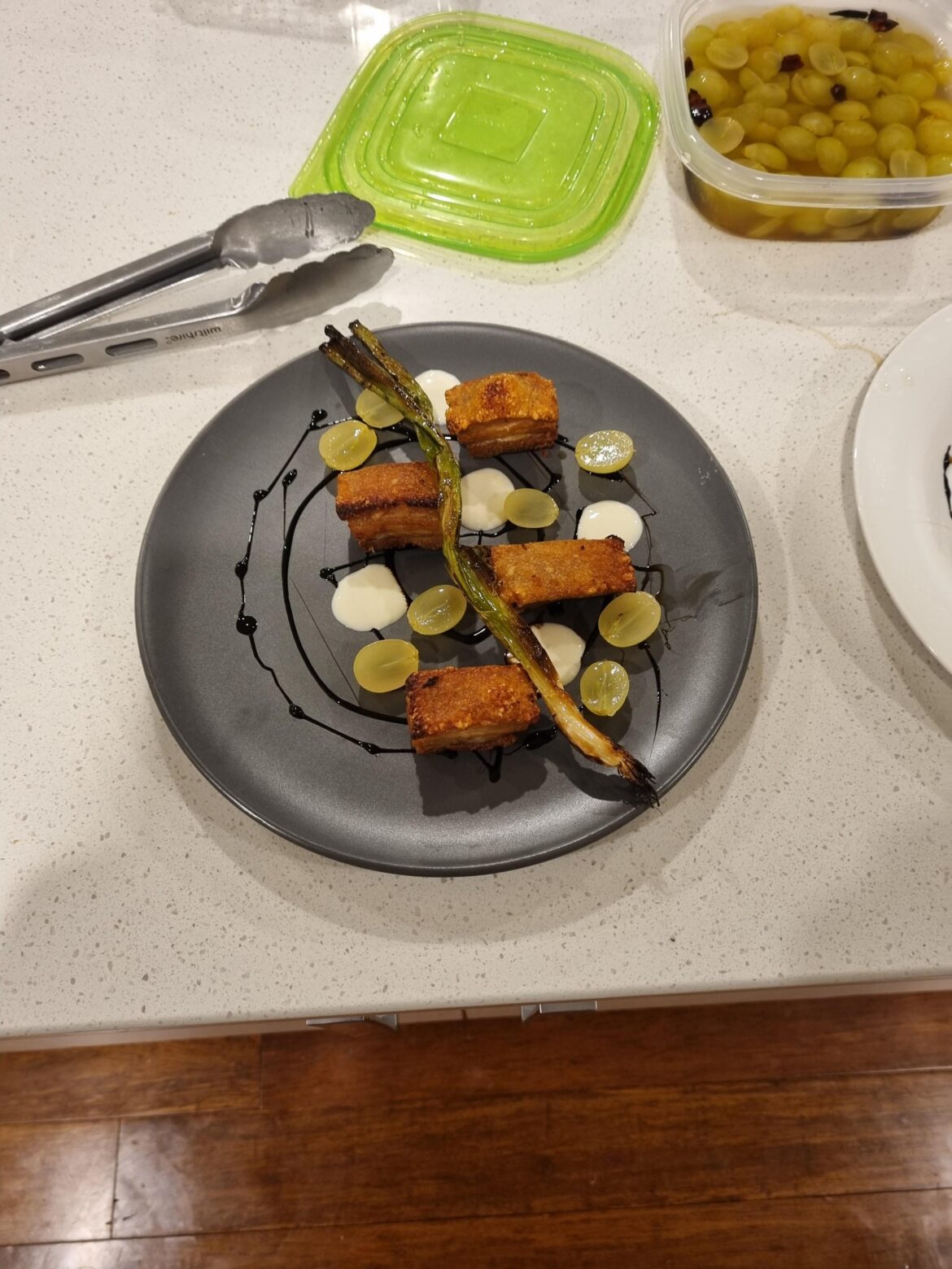 Porkbelly with Feta Cream, Balsamic glaze, pickled grapes and burnt scallion