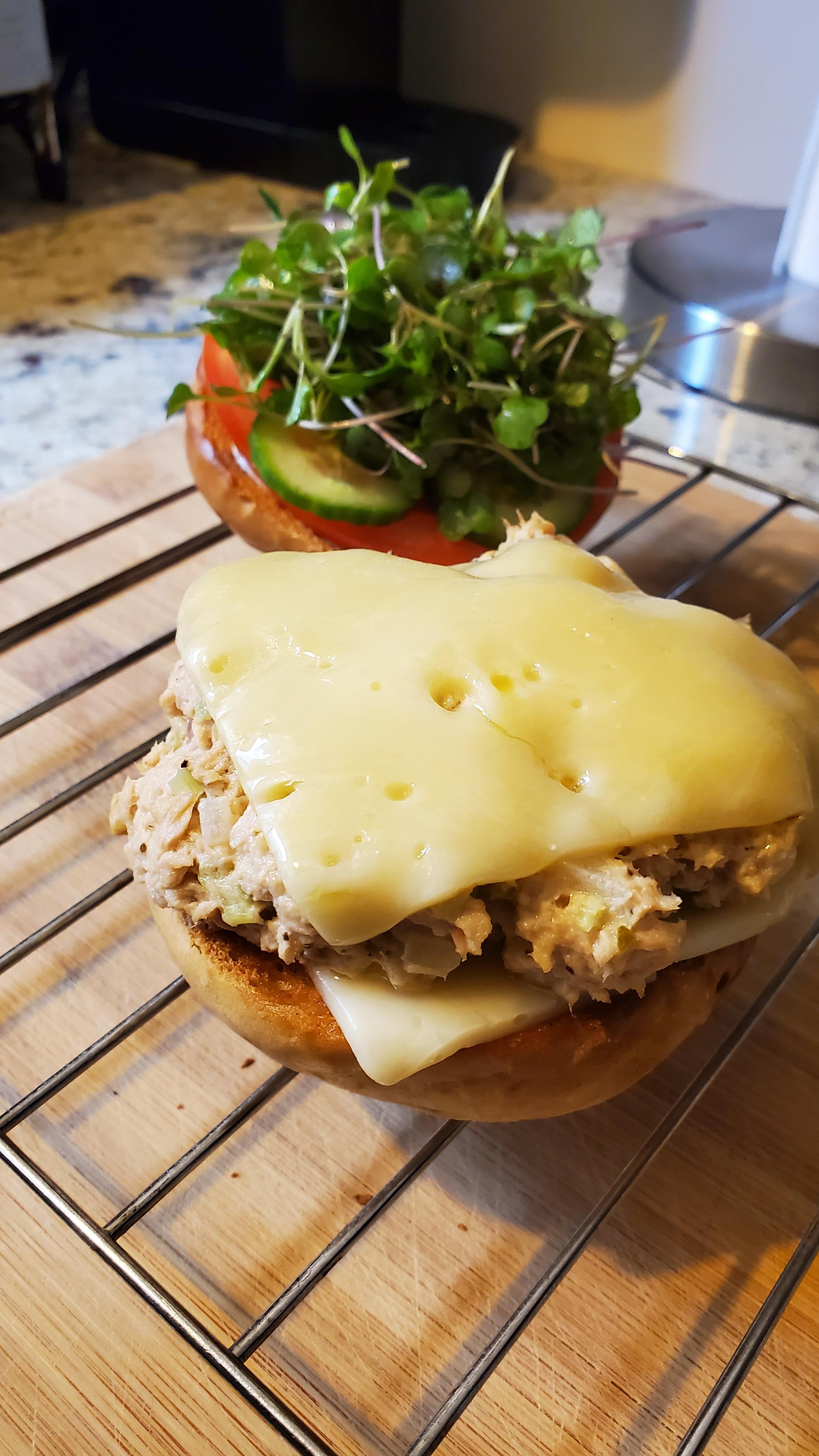 Tuna provolone melt on toasted pretzel bun with tomatoes, cucumbers