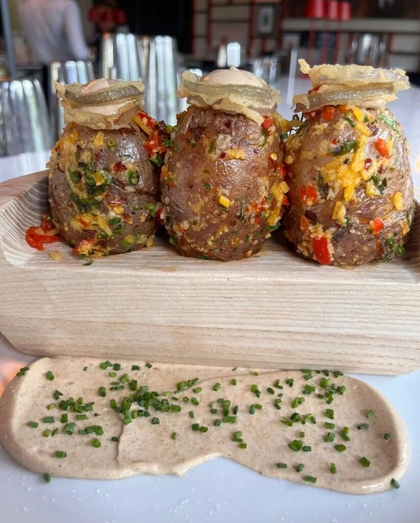 "Couch Potatoes" - what appears to be a loaded baker served on a wooden "couch", pinewood derby style.