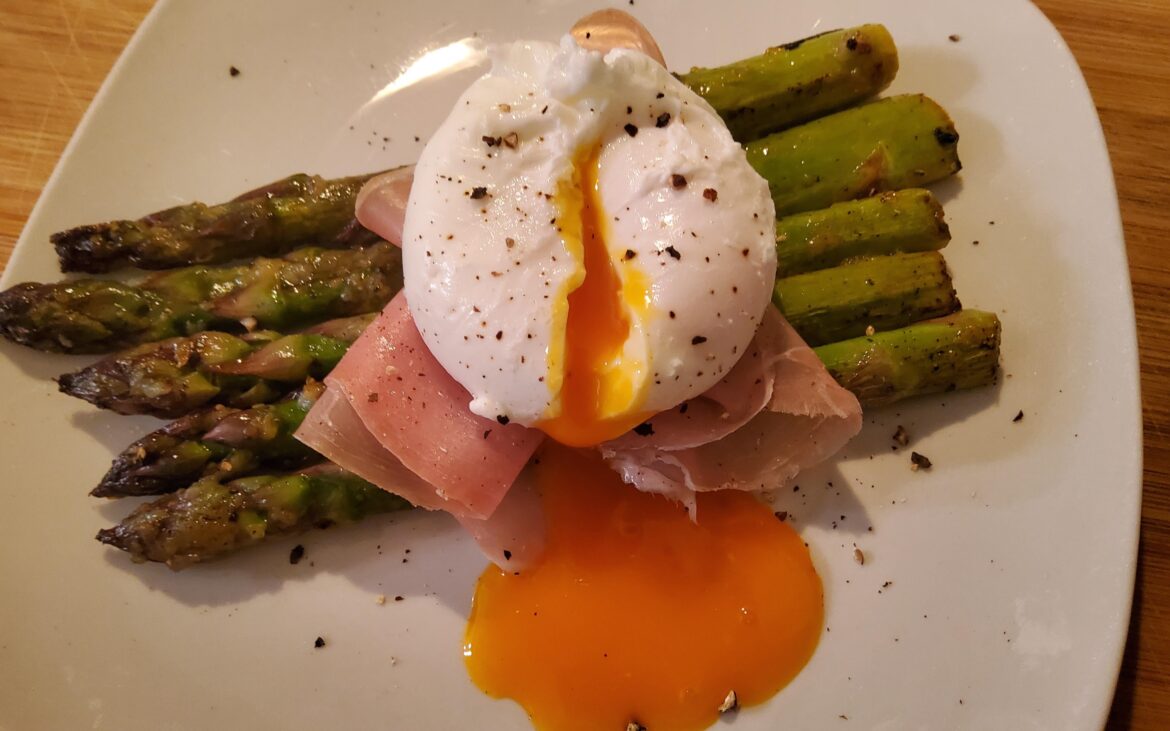 Grilled garlic lemon zest asparagus dressed with prosciutto topped with poached egg.