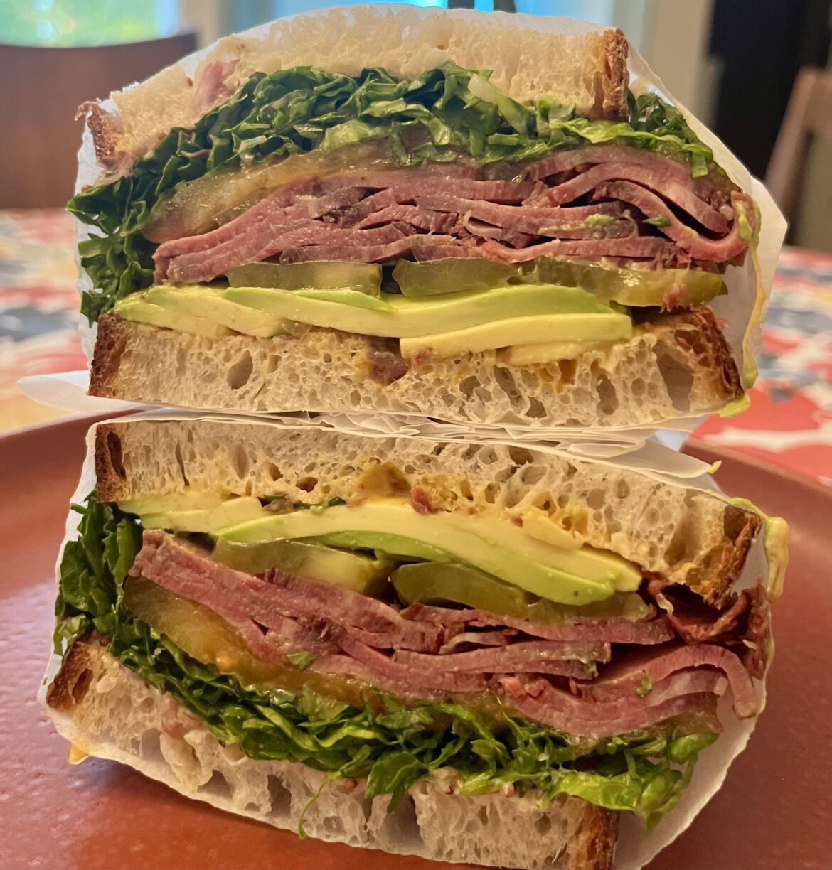 72h sous-vide harissa brisket, mayo, hot pepper relish, whole-grain mustard pickled shallots, shredduce, pickles, heirloom tomato, and avocado on sourdough francese.