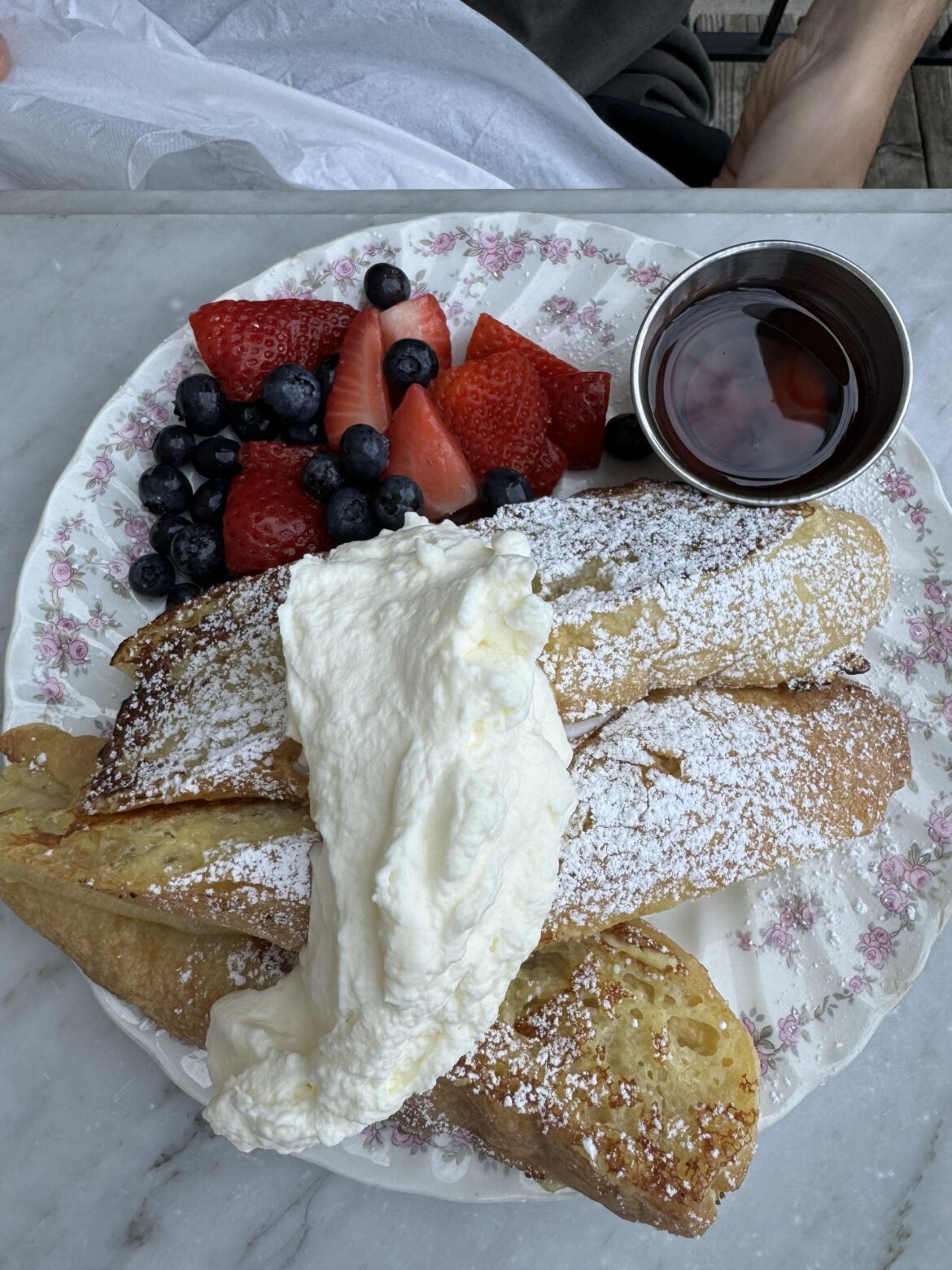 French toast with icing sugar, maple syrup, cream and berries