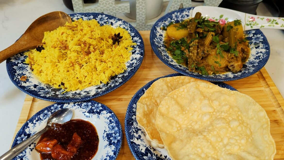Hekta Ni Hing Chicken Curry, combination of chicken and drumsticks (Moringa), paired with mung daal khichdi, poppadoms, and mango chutney.