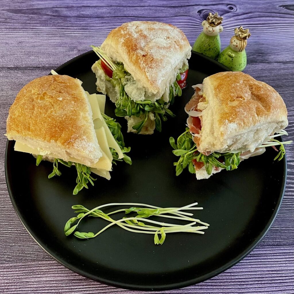 3 simple pea sprouts sandwiches: Swiss cheese/cream cheese, tomato/guacamole, Serrano/Dijon.