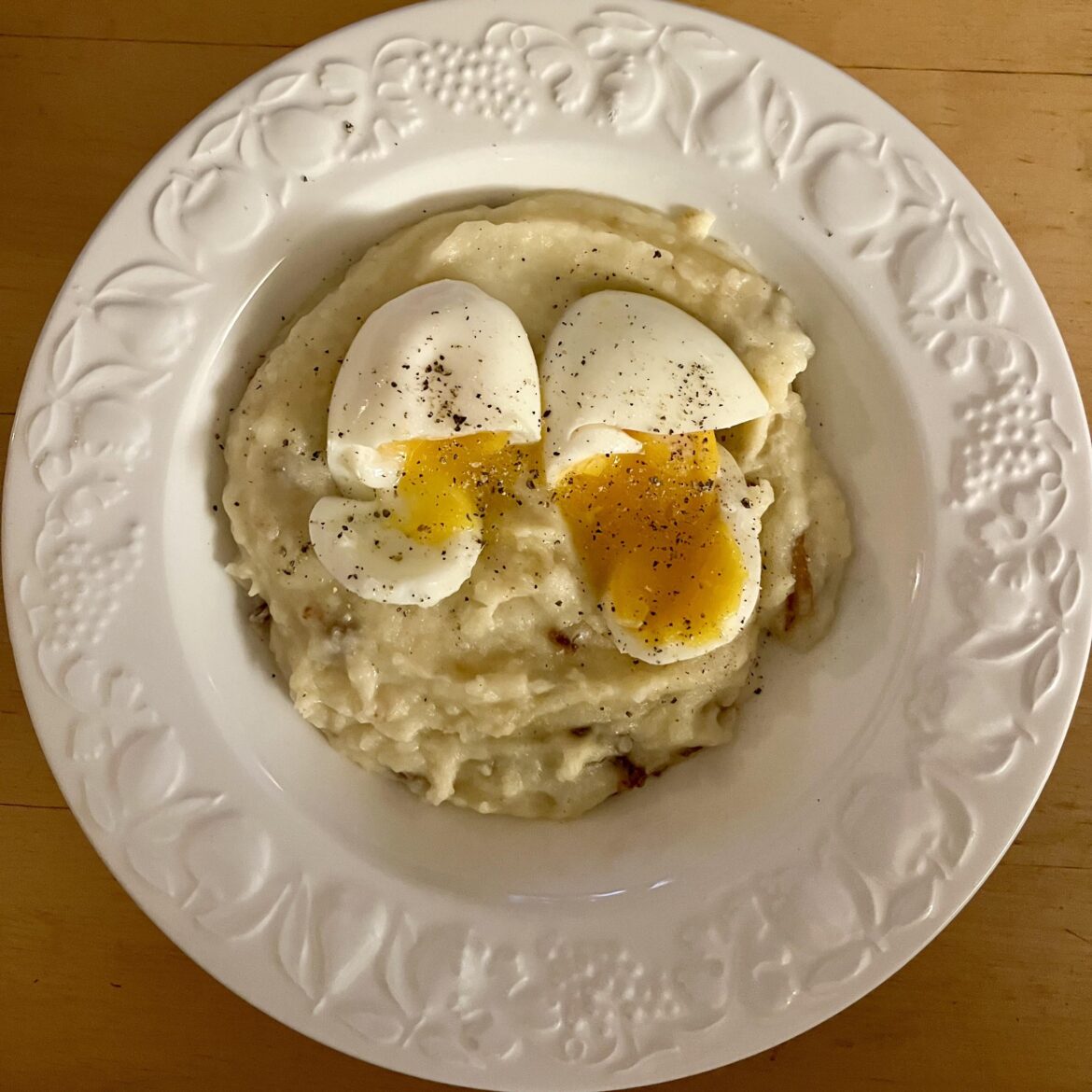 Mashed potatoes mixed with fried onions and two peppered eggs