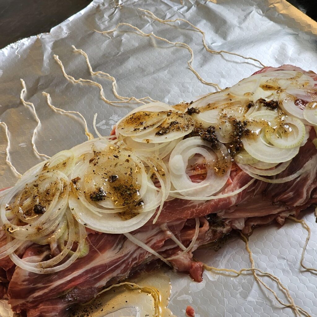 Successive layers of finely sliced pork neck and equally finely sliced onions, for tonight's gyros-style layered roast