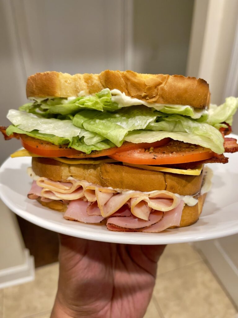 Honey baked Turkey, Ham and applewood bacon club on potato bread with Gouda and Dukes mayo