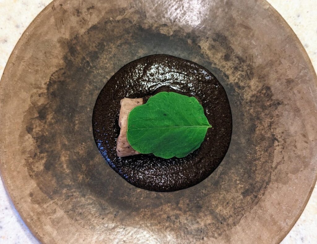 Tamal de ombligo, mole almendrado y pápalo