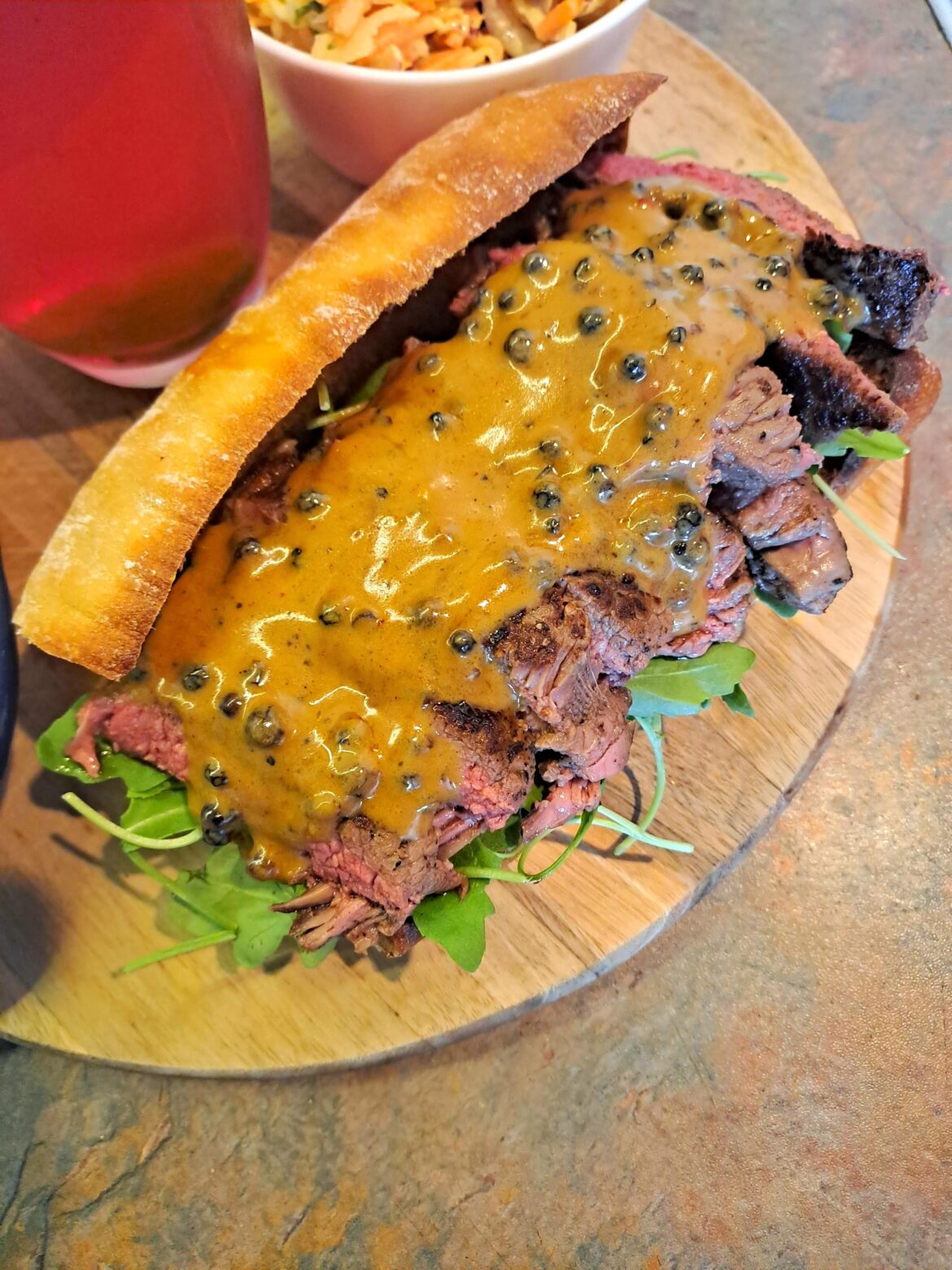 Made a Steak Sandwich with fried onions, rocket and topped with a peppercorn sauce