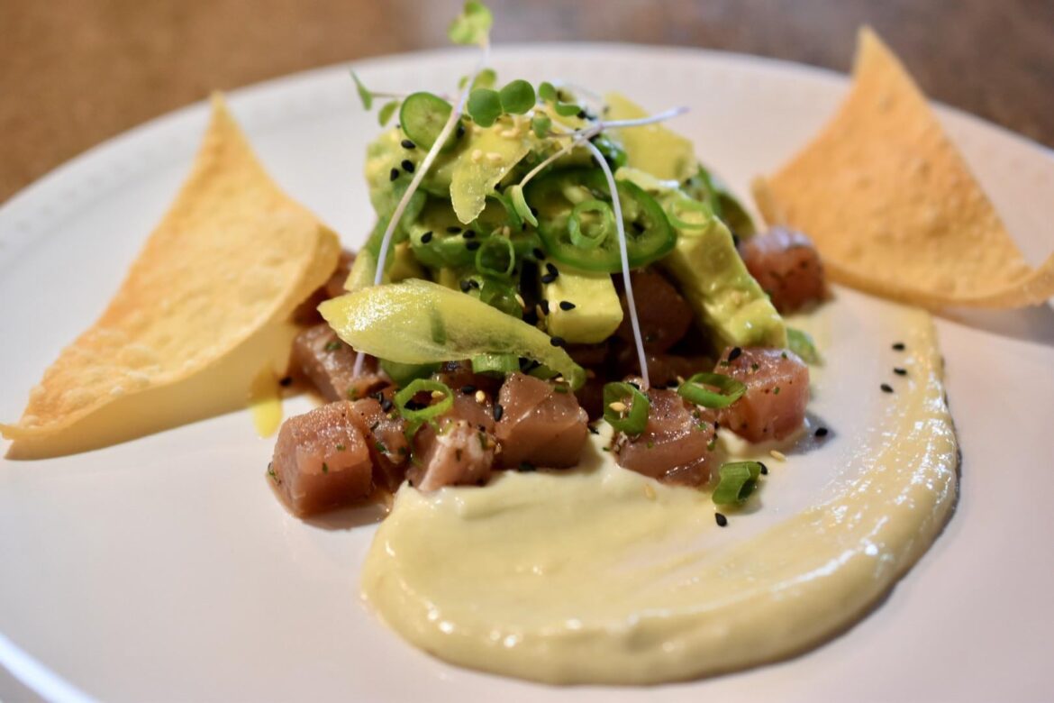 Tuna and avocado tartare with pickled ginger, jalapeño, scallions, radish sprouts, sesame seeds, wonton skins & wasabi aioli