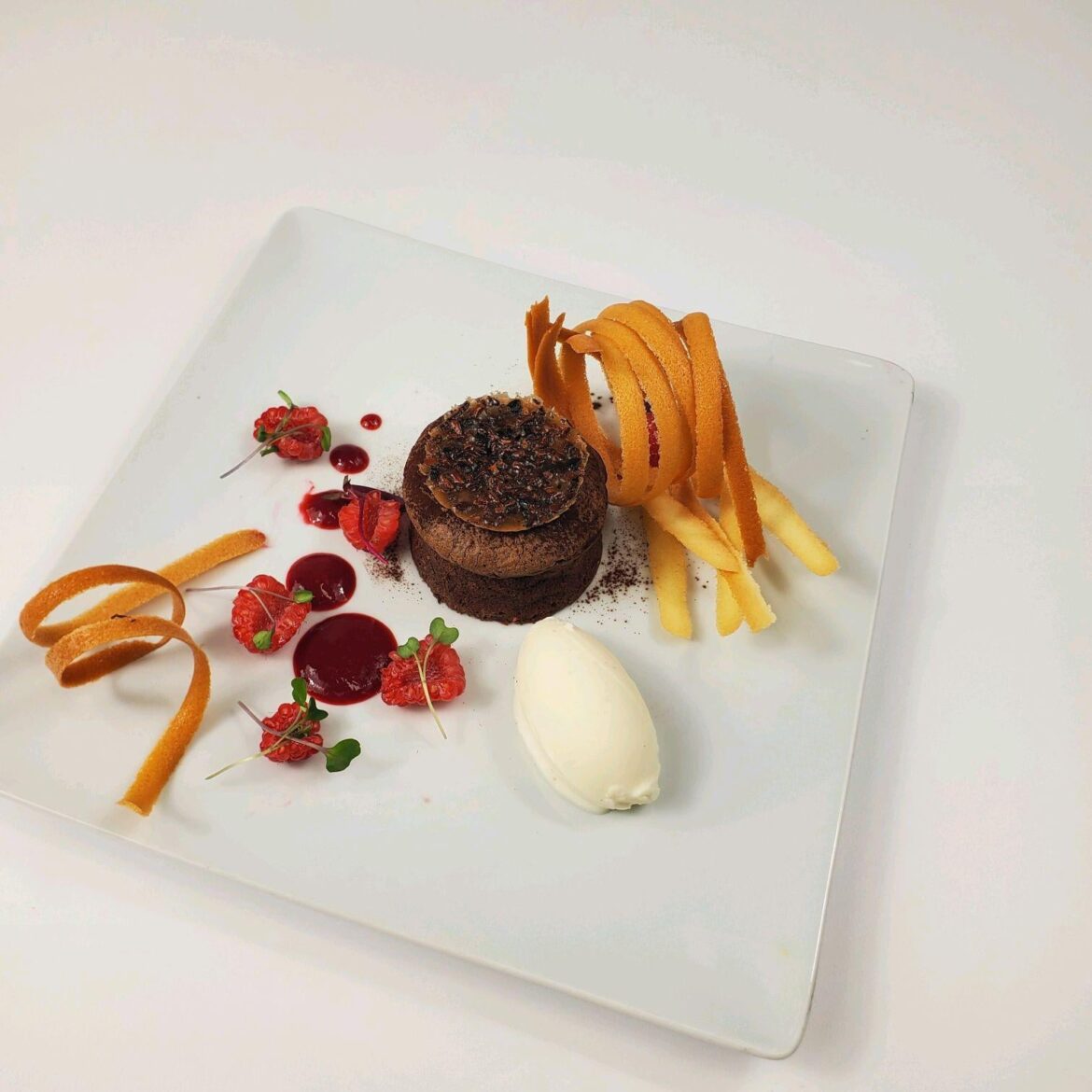 Gluten free molten lava cake with rasberry sauce and vanilla bean gelato