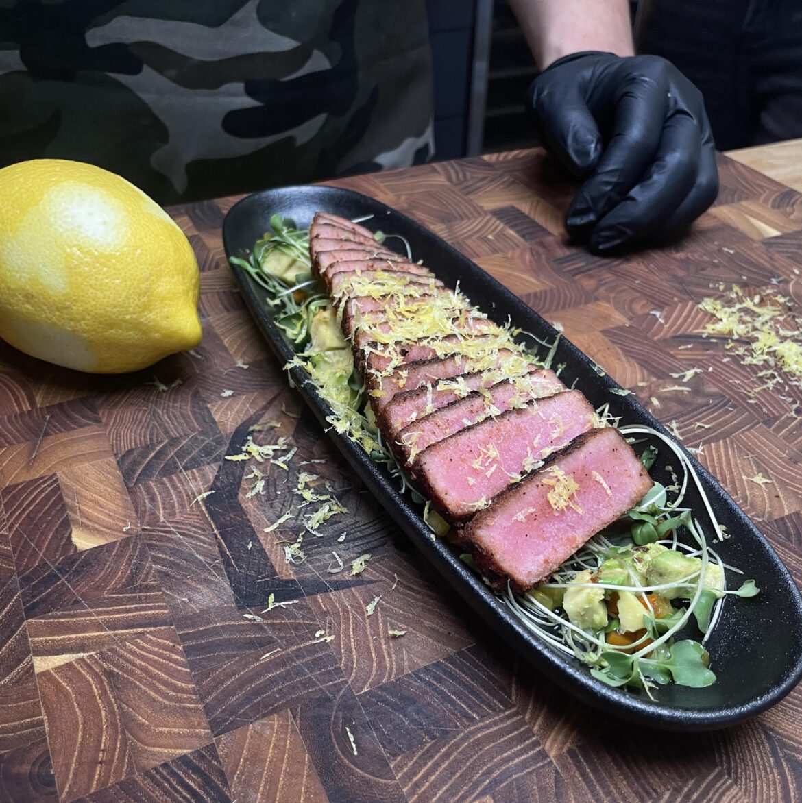 Seared Tuna Tataki on a bed of herbs, avocado and a citrus finish.