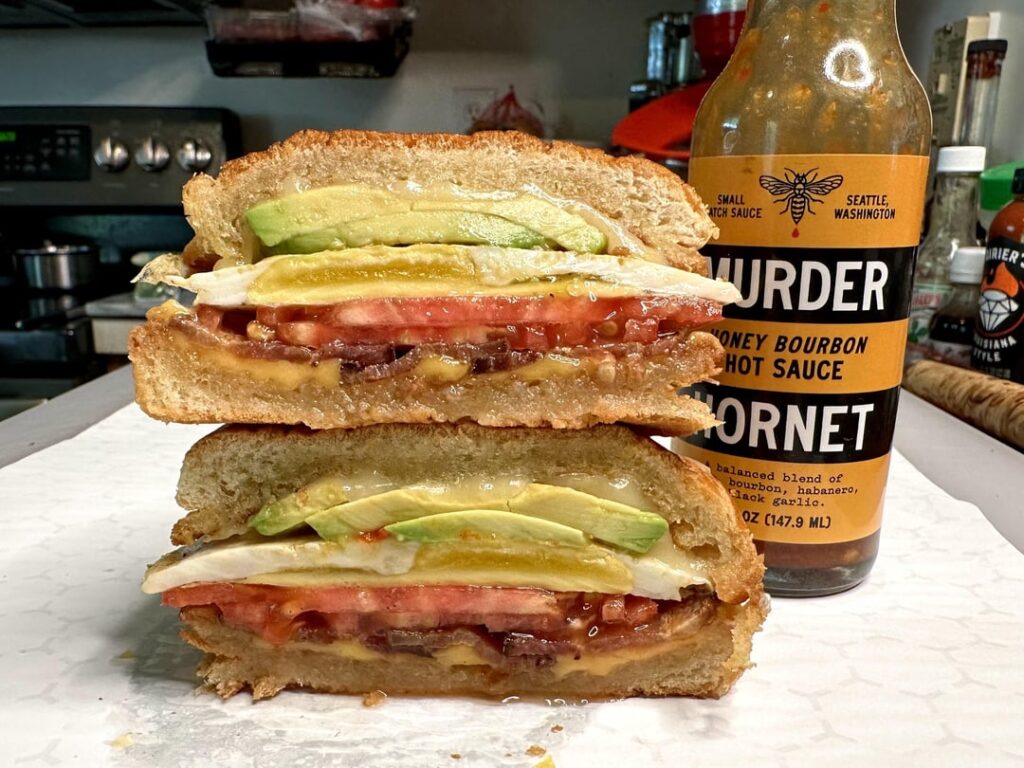 Bacon, egg, cheese, tomato, and avocado breakfast sandwich