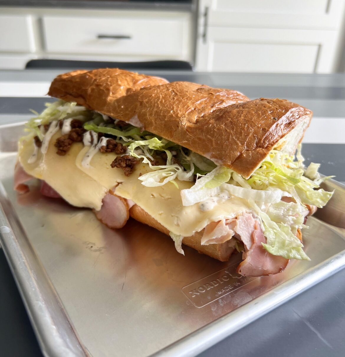 My homemade version of our local classic: A North Dakota-style Taco Grinder. Piled high with salami, ham, turkey, cheese, taco meat, lettuce, hot sauce, and white sauce